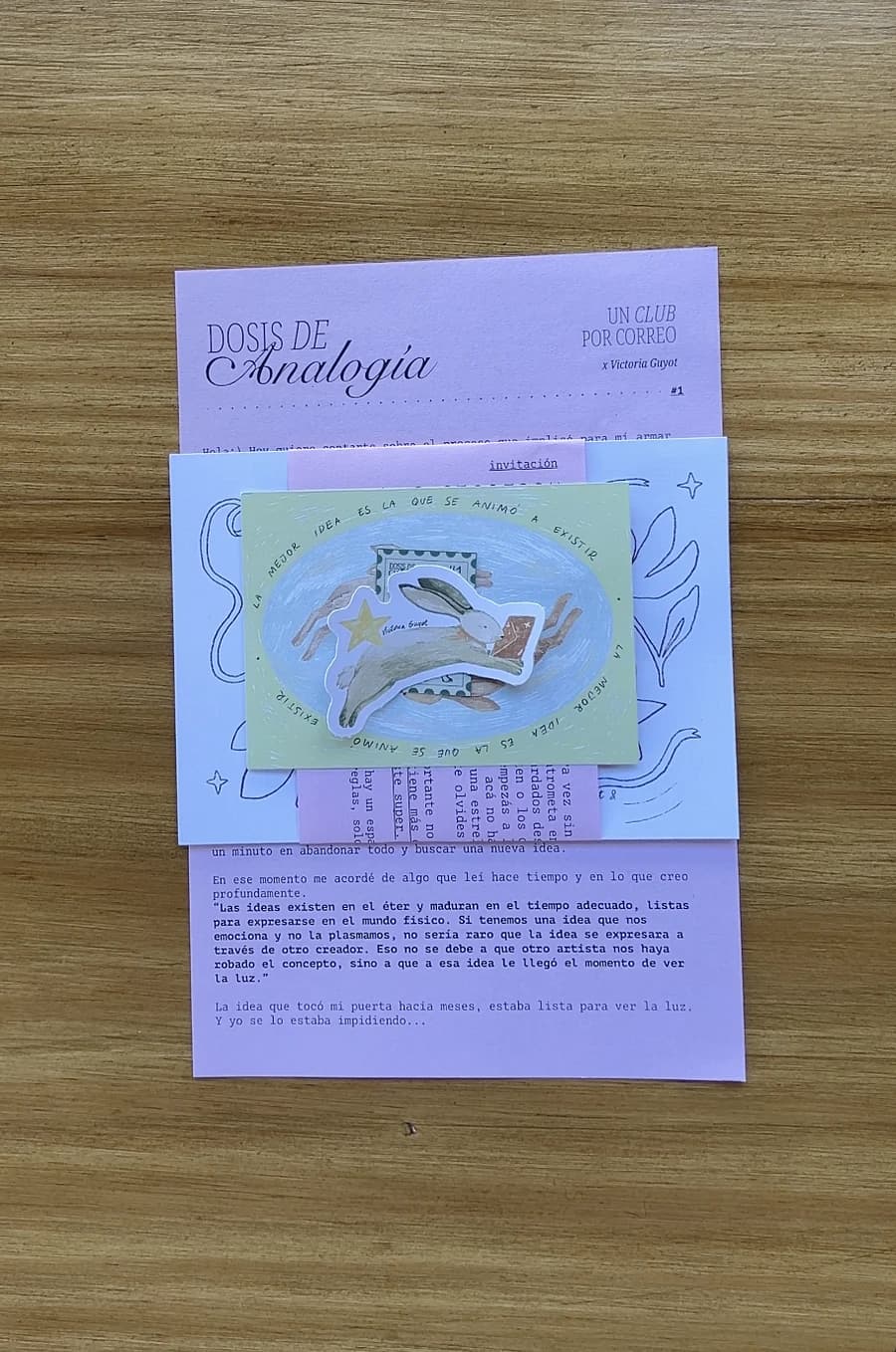La carta rosa de la primera edición con la postal del conejo, el sticker del conejo saltando y una estrella dorada.